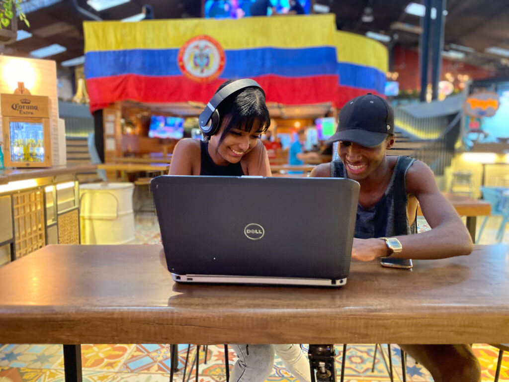 Alunos sorrindo em um laptop